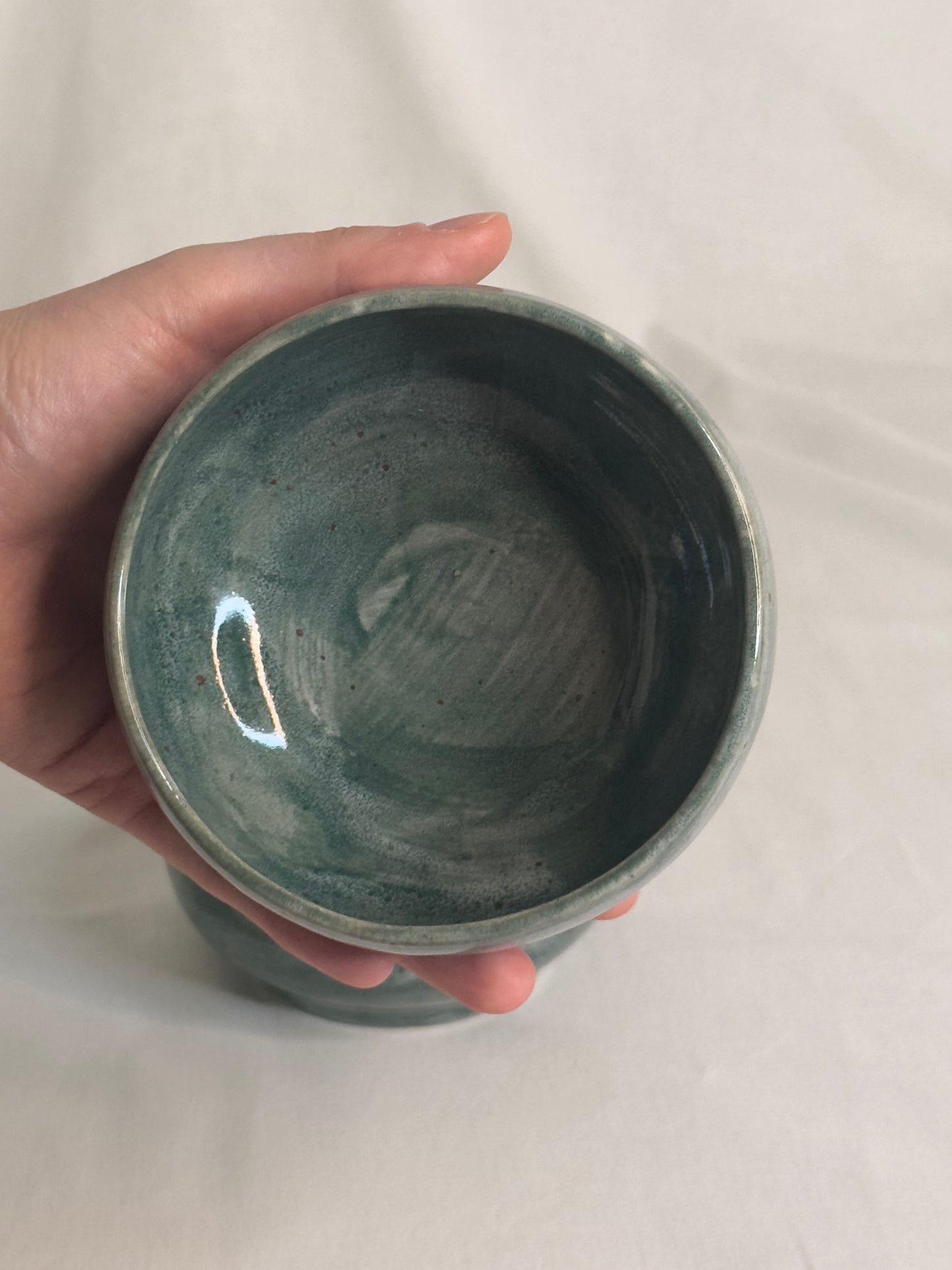Bol artisanal en céramique émaillée vert foncé, avec des nuances de gris et des détails mouchetés. Idéal pour les petits déjeunés, soupes, salades ou autres plats, il ajoute une touche élégante et naturelle à la table.