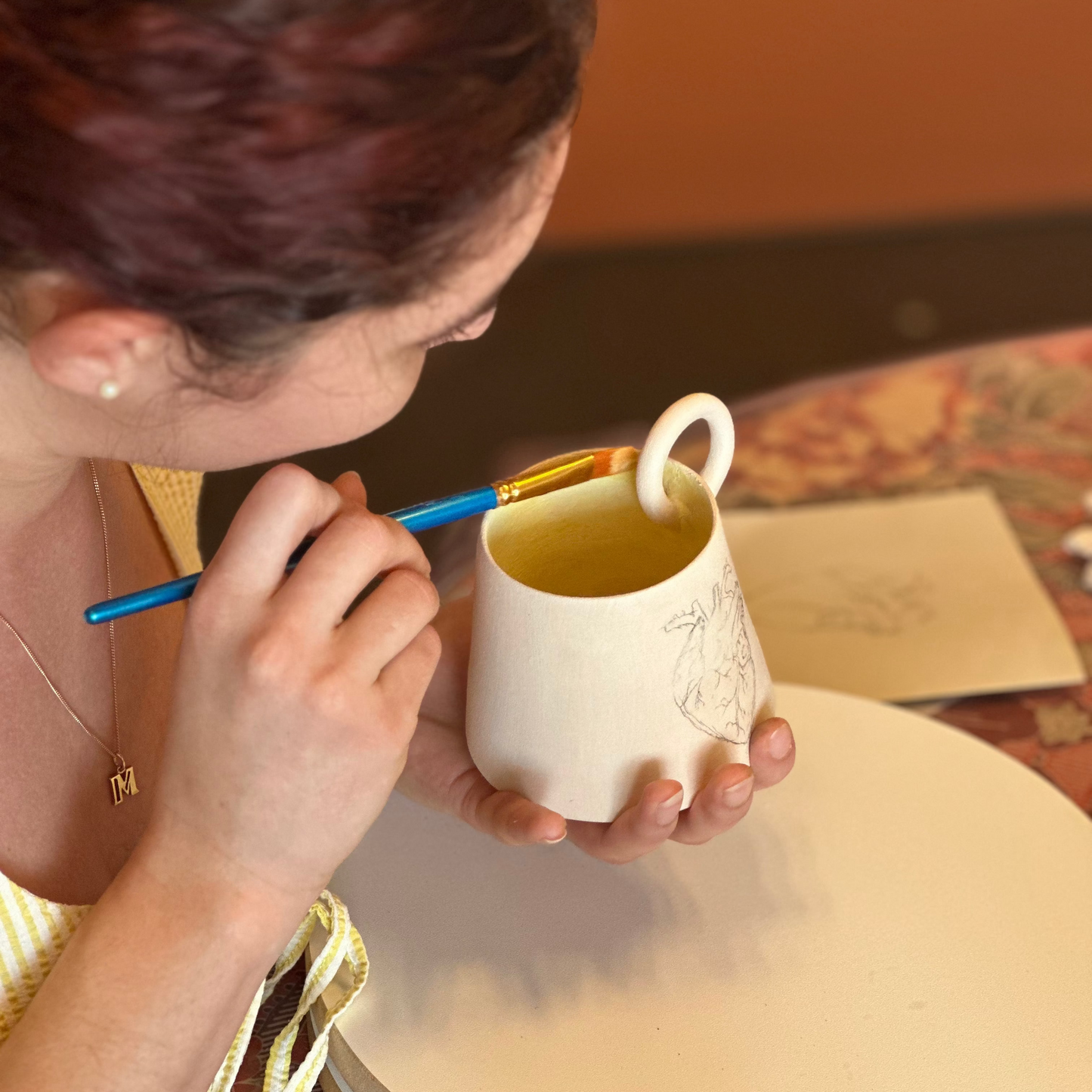 Participante peignant des céramiques artisanales lors d'un atelier à Toulouse
